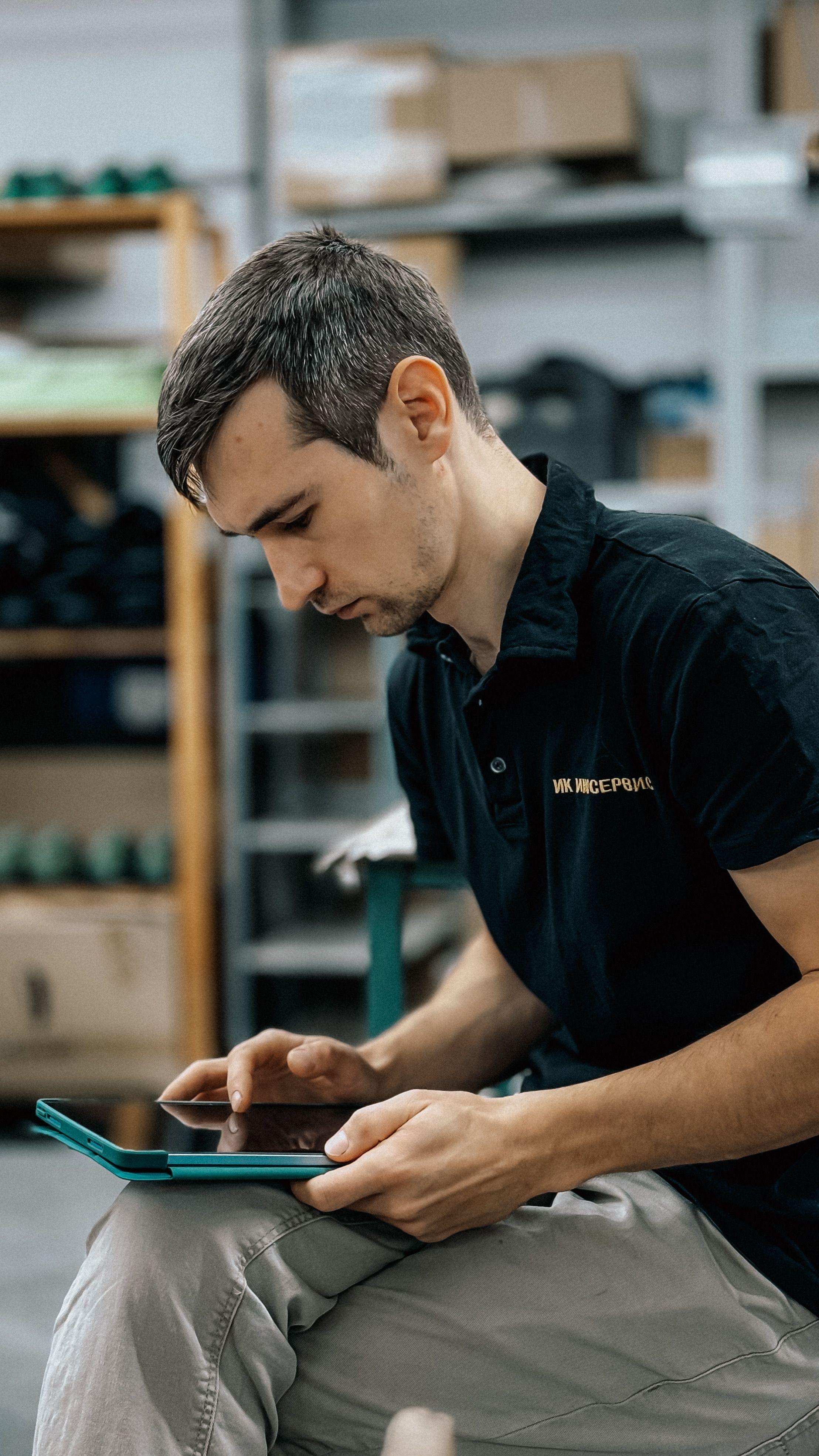 Pracownik magazynu z tabletem — synchronizacja stanów i zamówień